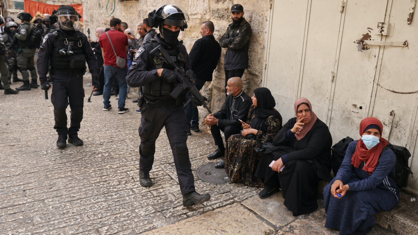 Israeli border police patrol in front of the Lion's Gate in Jerusalem's Old City, as Palestinians wait to be allowed to enter the al-Aqsa mosque compound, on 17 April 2022 (AFP)