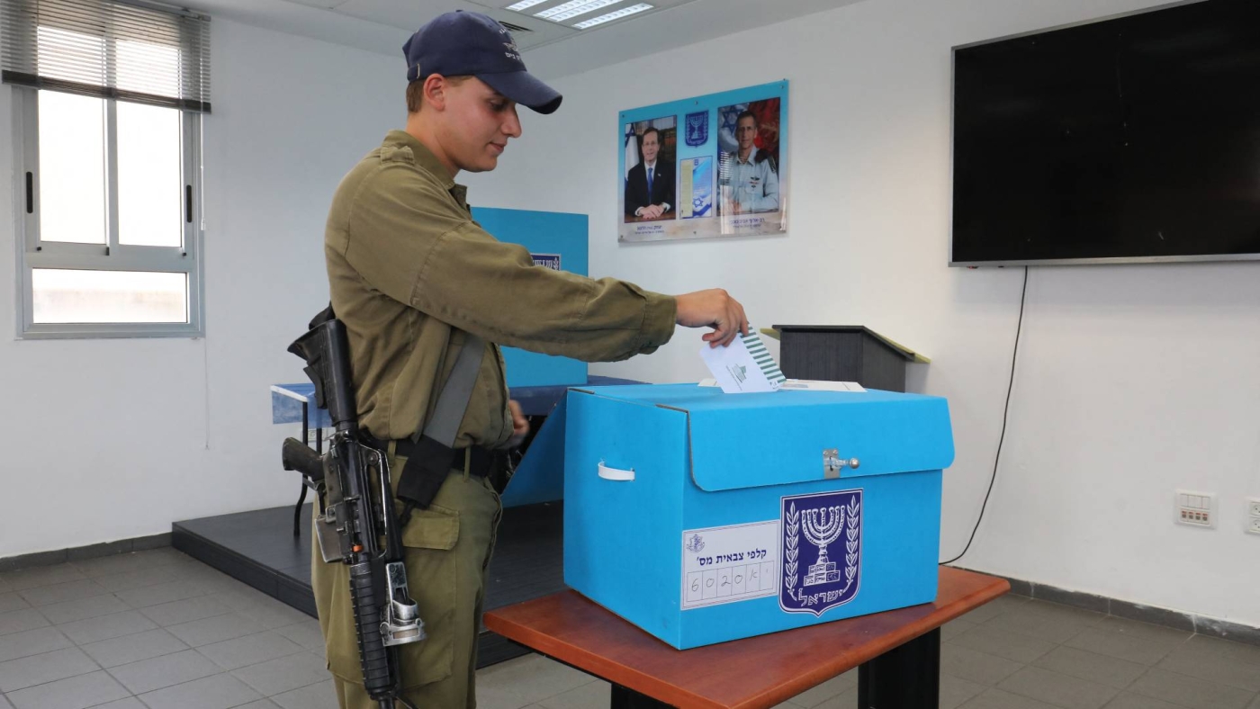 An Israeli soldier casts his ballot for the general elections at a military base in the city of Ashdod, 30 October 2022 (AFP)