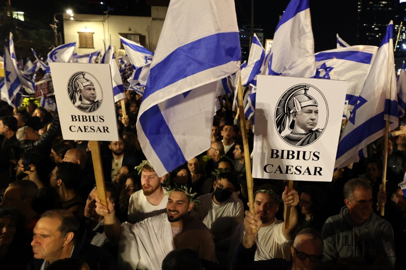 Israeli protesters carry placards depicting Benjamin Netanyahu as Julius Caesar during a demonstration against his new hard-right government, Tel Aviv, 21 January 2023 (AFP)