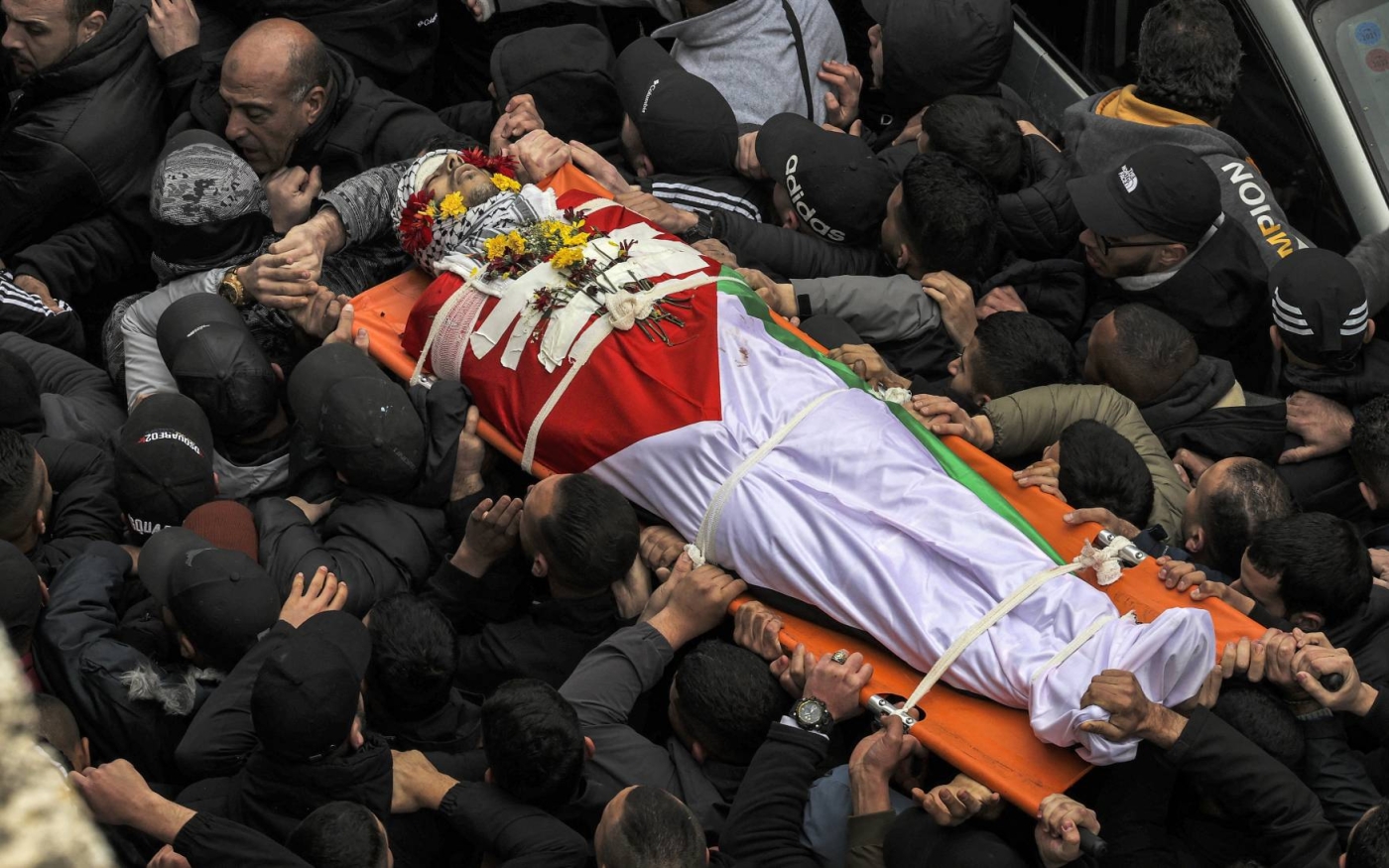 Mourners carry the body of Palestinian Alaa Shaham during his funeral at the Qalandia camp for Palestinian refugees south of Ramallah in the occupied West Bank on March 15, 2022