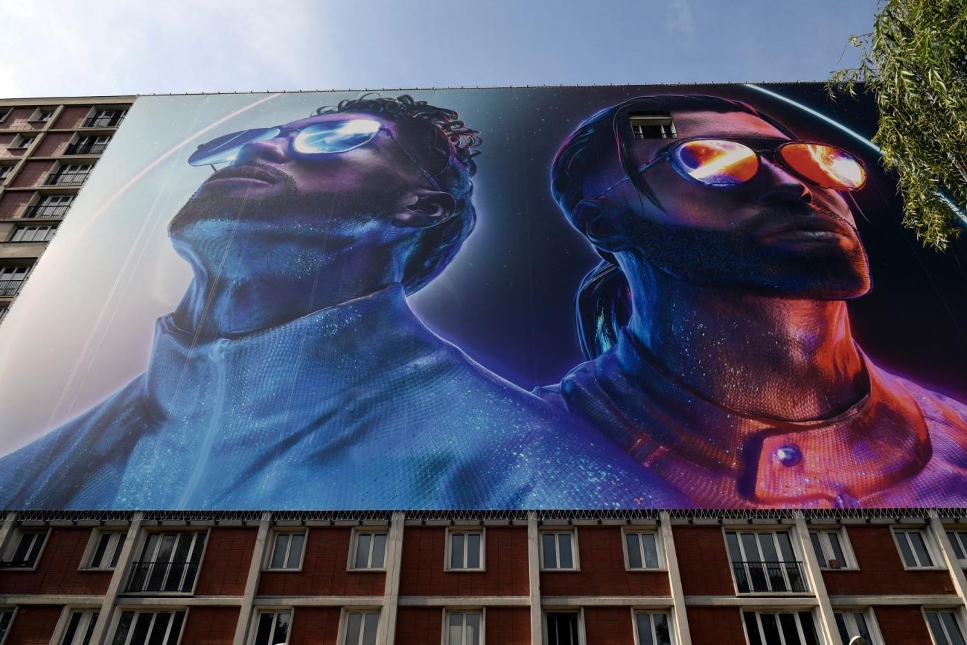 Une banderole représentant Ademo et N.O.S (Tarik et Nabil Andrieu) du groupe de rap PNL, sur un bâtiment où ils ont passé une partie de leur adolescence, à Ivry-sur-Seine, en banlieue parisienne (AFP/Lionel Bonaventure)
