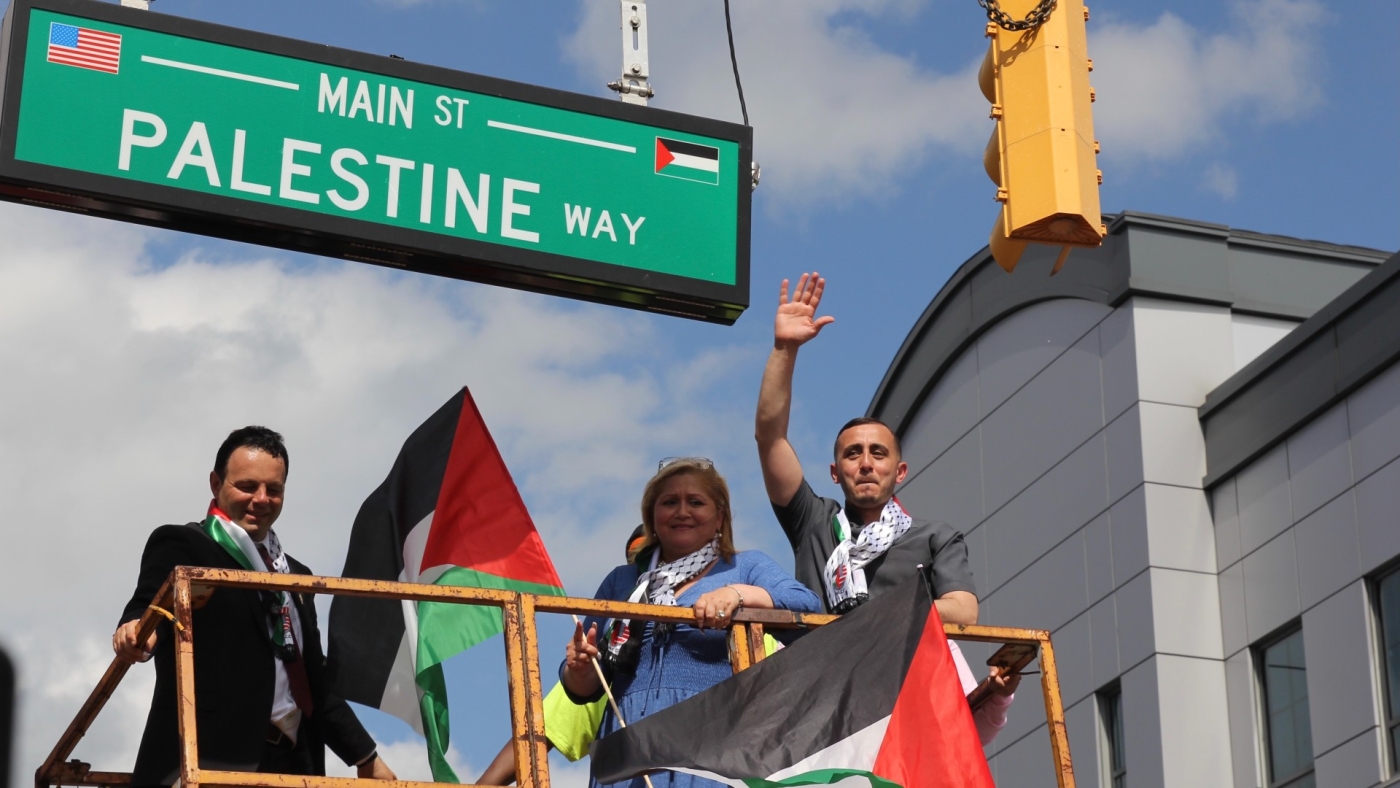 Paterson City Mayor Andre Sayegh, City Council President Maritza Davila and Councilman Alaa Abdelaziz pose next to the new 'Palestine Way' street sign (MEE/Reem Farhat)