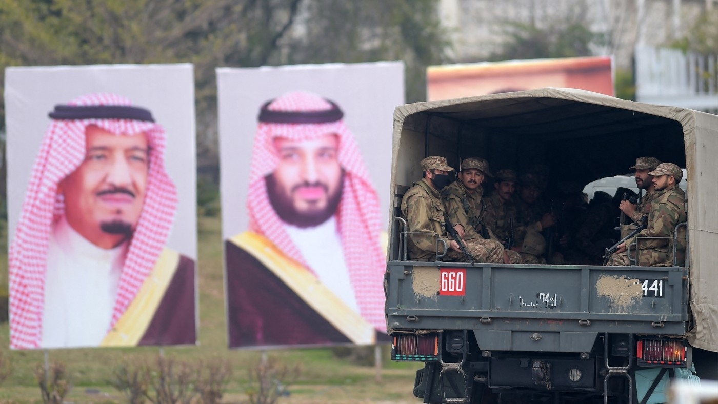 Pakistani soldiers patrol next to welcoming posters of Saudi Arabian Crown Prince Mohammed bin Salman in Islamabad, in 2019 (AFP)