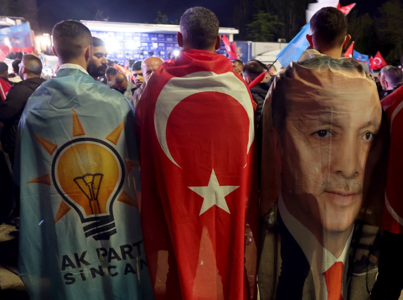 Supporters draped in the flags of the AK Party, Turkish flag and image of Turkish President Erdogan outside AK Party headquarters in Ankara, 15 May 2023 (AFP)