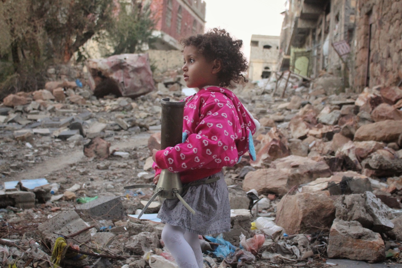 Une fillette tient un éclat d’obus, à Ta'izz, en mars 2021 (MEE/Khalid al-Banna)