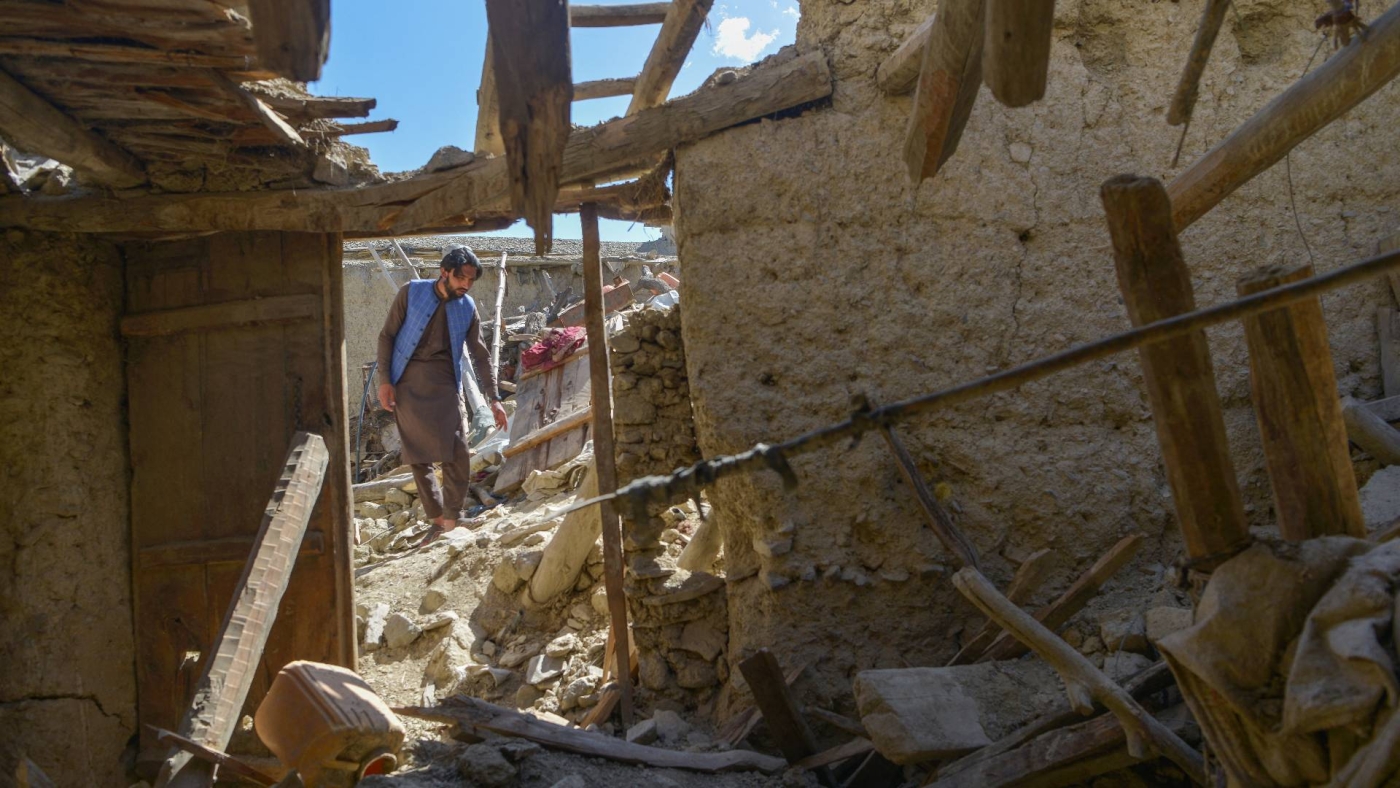 An Afghan man looks for his belongings amid the ruins of damaged houses after an earthquake in Gayan district, Paktika province, on 24 June 2022.