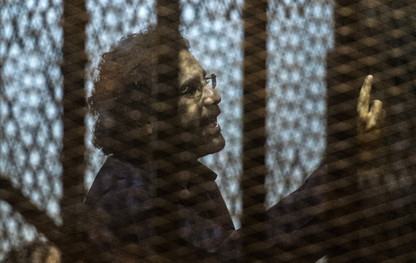 Egyptian activist Alaa Abd El-Fattah gestures from the defendant’s cage during his trial in Cairo in May 2015 (AFP)