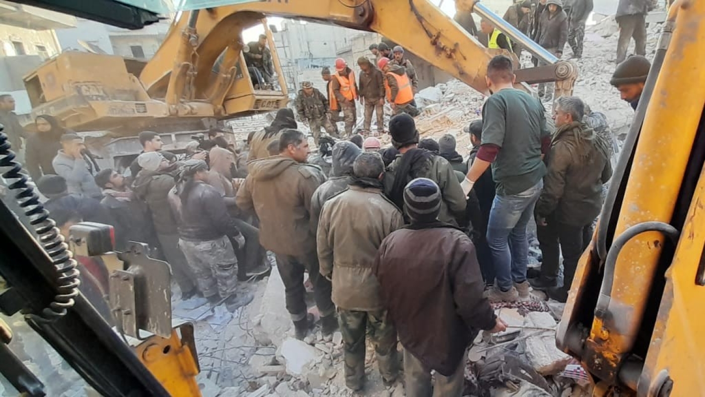 People gather as rescue teams search the rubble after a residential building collapsed in Syria's second largest city Aleppo on 22 January 2023 (Syrian Observatory for Human Rights)