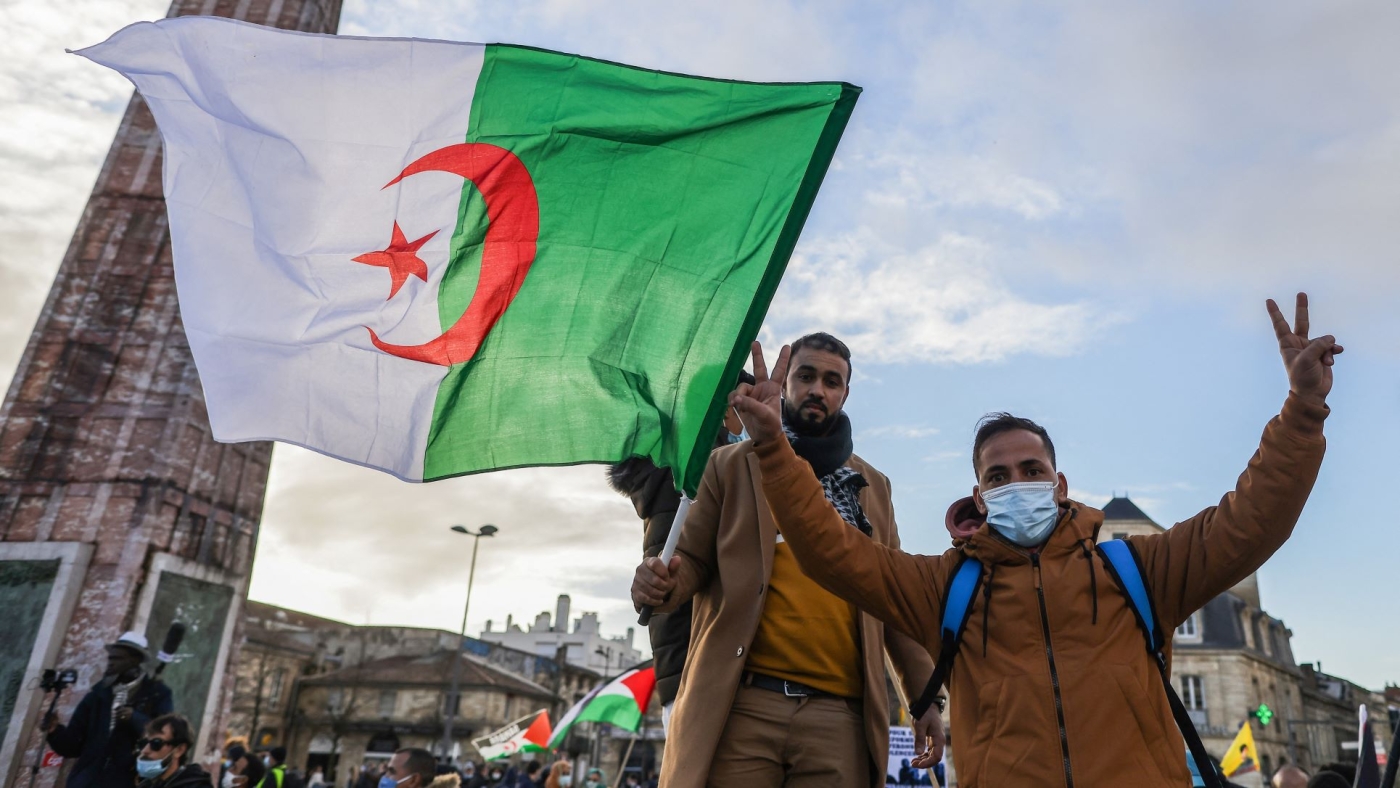 Algerian men wave their country's flag in the French city of Bordeaux (AFP)
