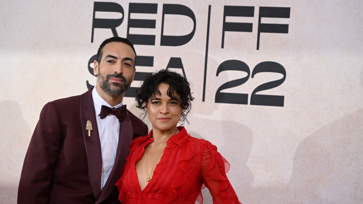 Le producteur saoudien Mohammed al-Turki et l’actrice hollywoodienne Michelle Rodriguez posent devant une publicité pour le Festival du film de la mer Rouge à Cannes, en mai 2022 (AFP/Patricia De Melo Moreira)
