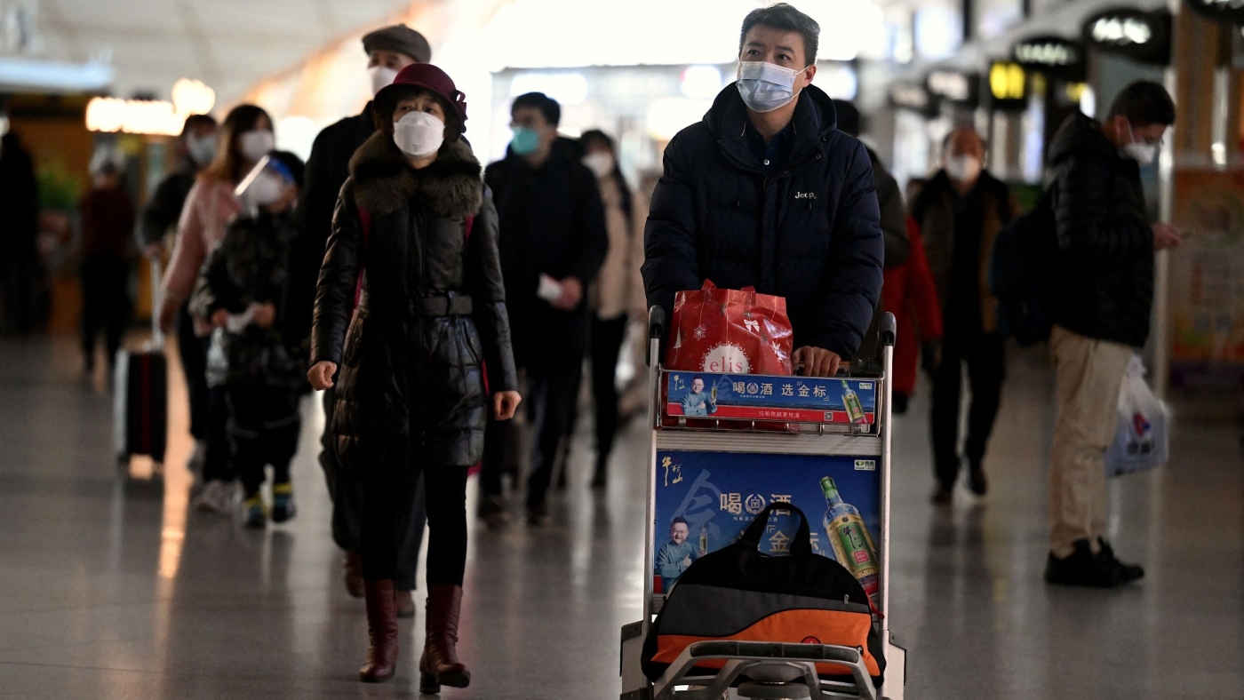 Passengers walk through a departure terminal of the international airport in Beijing on 29 December 2022 (AFP)