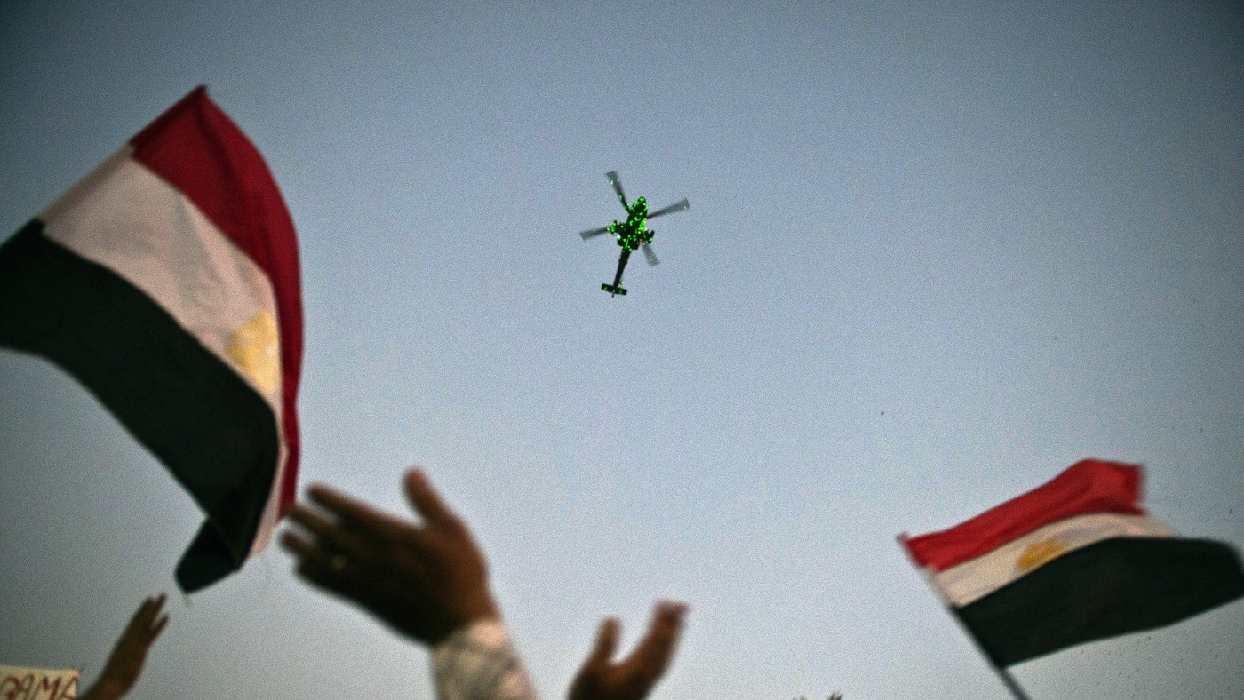An Egyptian military helicopter flies over thousands rallying on 7 July 2013 in Cairo's Tahrir Square (AFP)