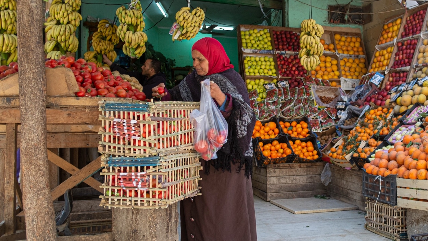 An Egyptian woman shops at a fruit market in Cairo on 17 March, 2022 (AFP)