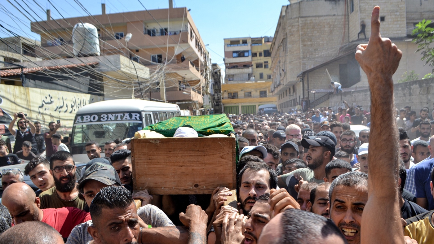 Mourners march with the body of one of the victims who drowned in a shipwreck off the Syrian coast, during his funeral on the outskirts of the Lebanese city of Tripoli on 24 September 2022 (AFP)