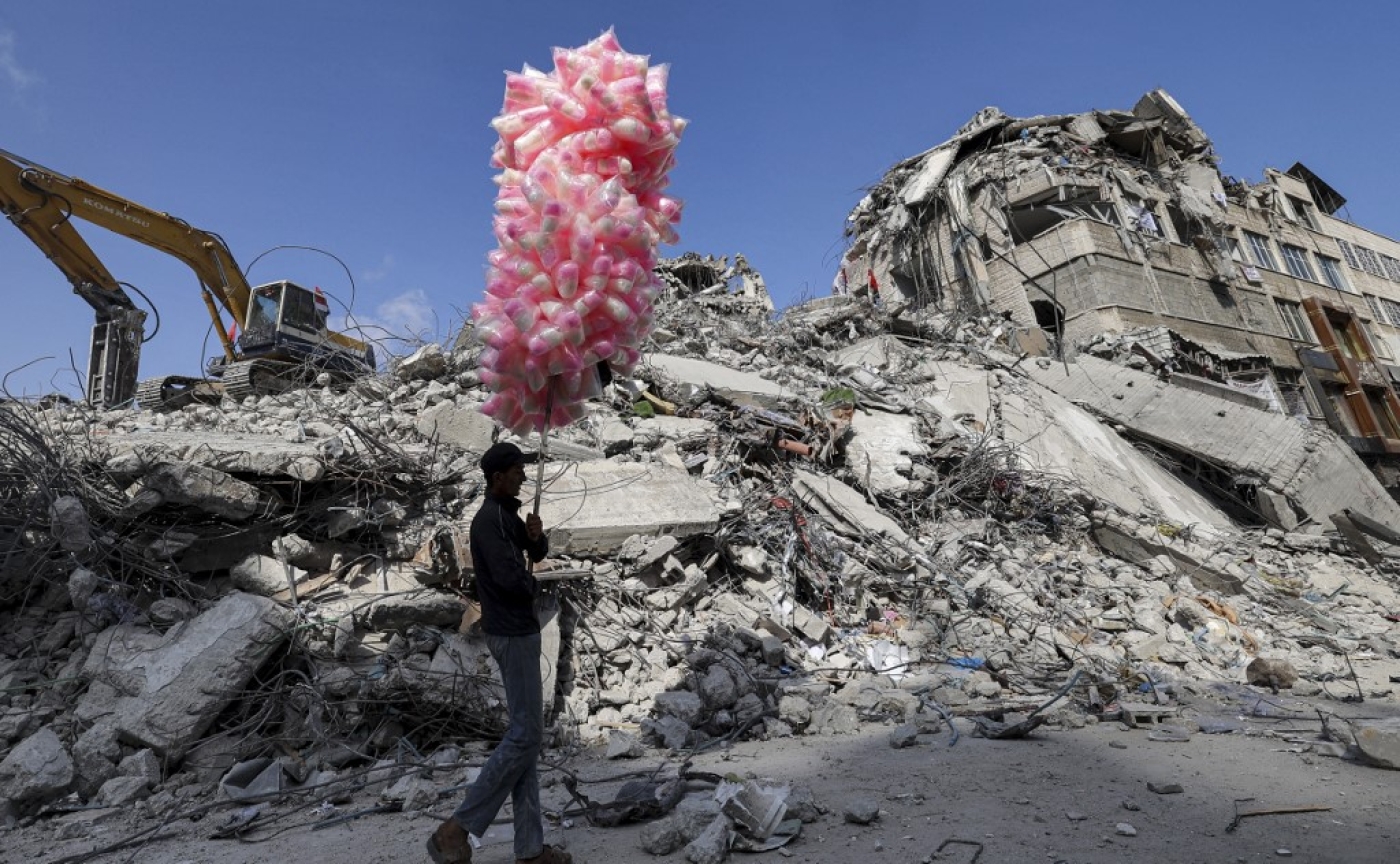 A Palestinian walks past the rubble of a building destroyed during the Israeli offensive on Gaza on 10 June 2021.