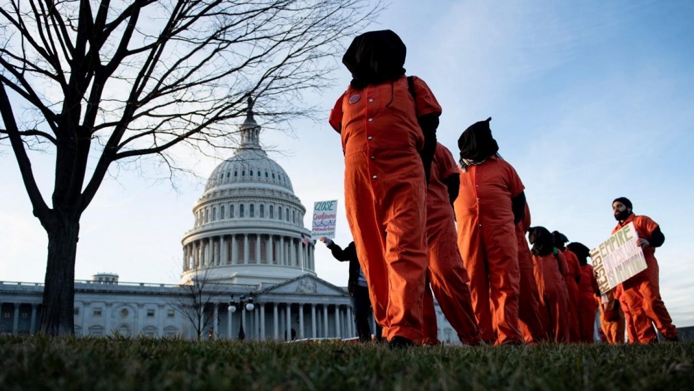 Demonstrators dressed in Guantanamo Bay prisoner uniforms march past Capitol Hill on 9 January 2020.