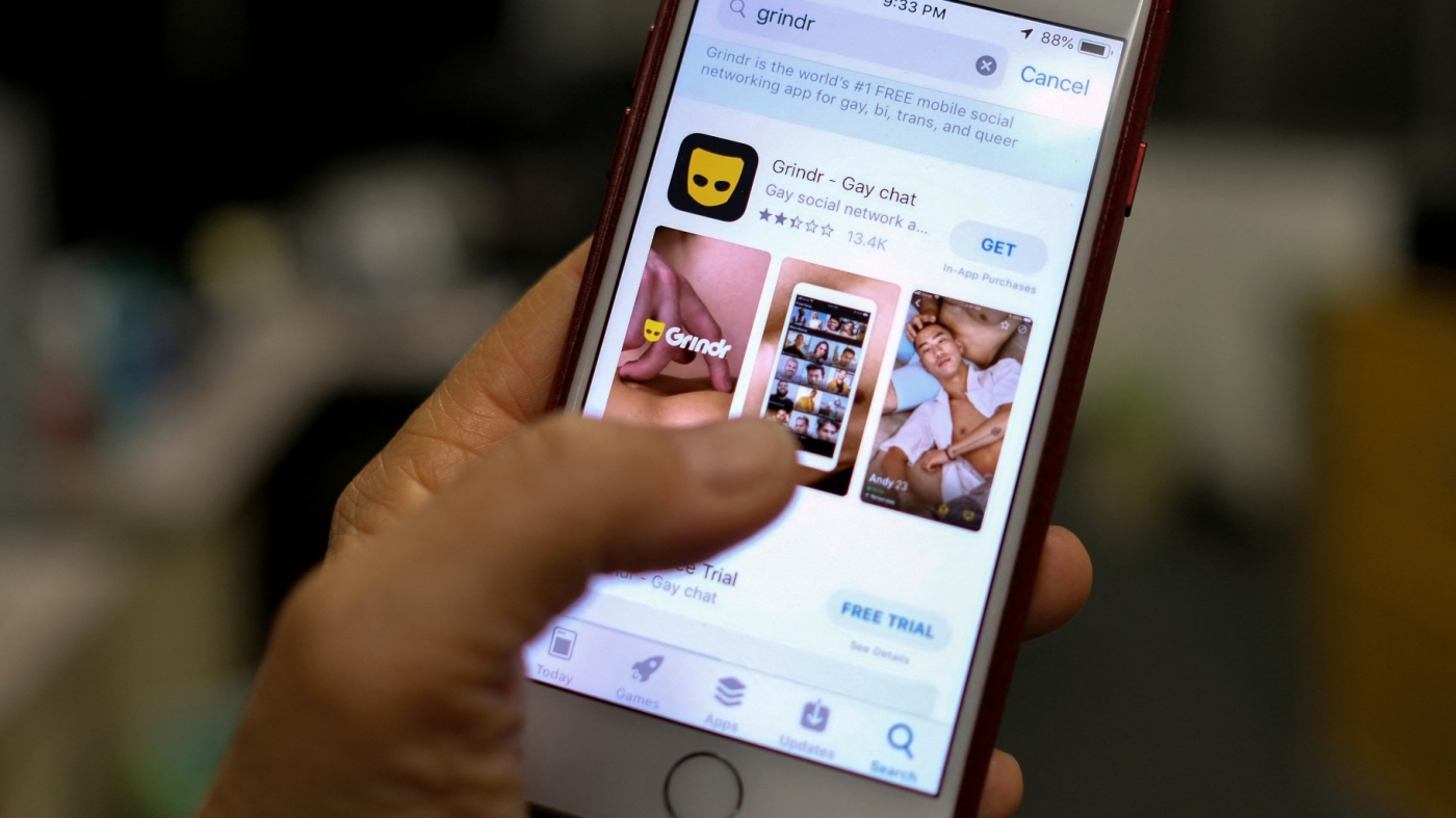 A person looks at the Grindr app in the App Store on a phone (AFP/File photo)