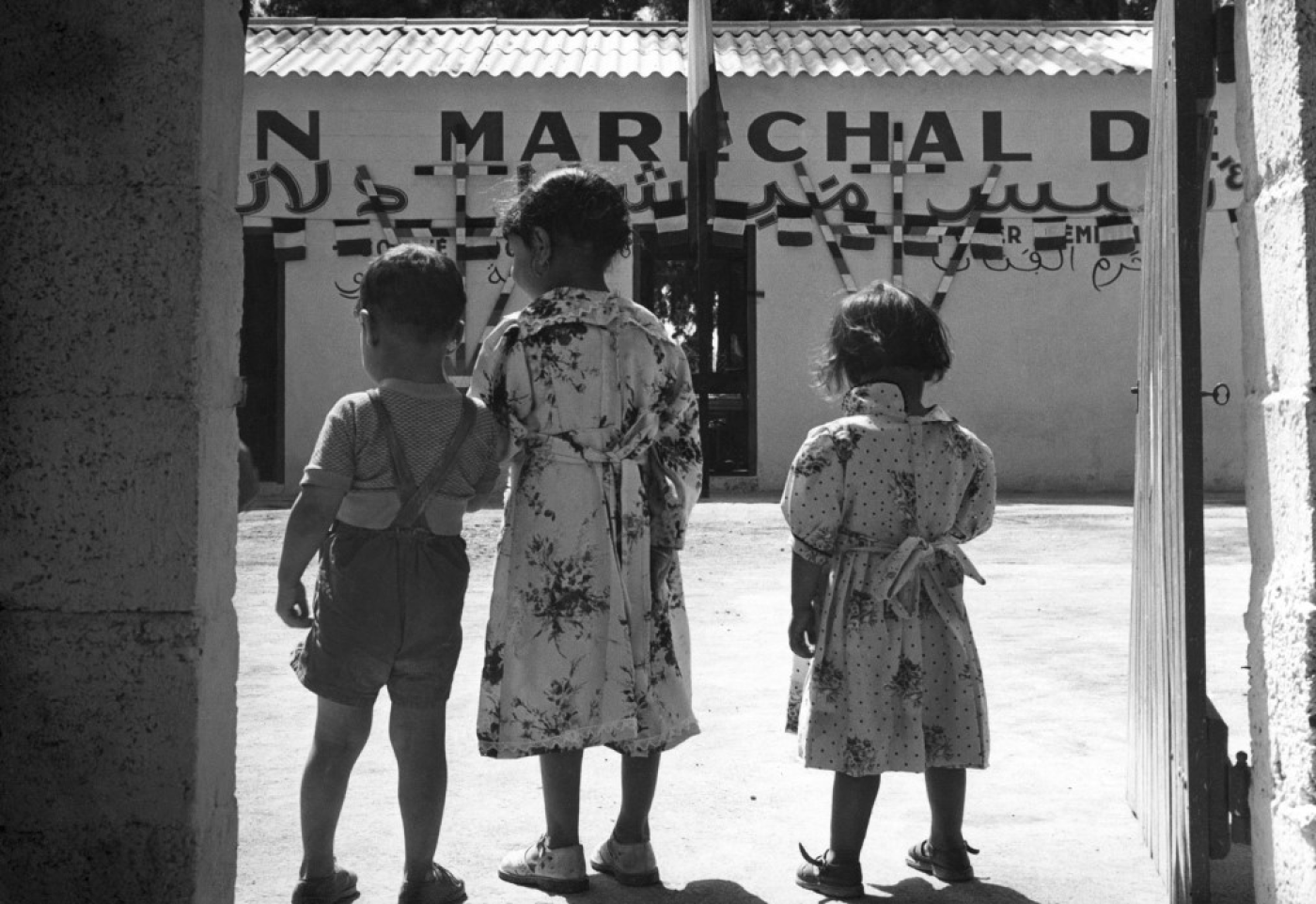 Photo prise en 1958 de trois enfants algériens qui se tiennent devant le bâtiment de la Fondation Maréchal de Lattre à Palestro, en Haute Kabylie, à 79 kilomètres au sud-est d’Alger (AFP)