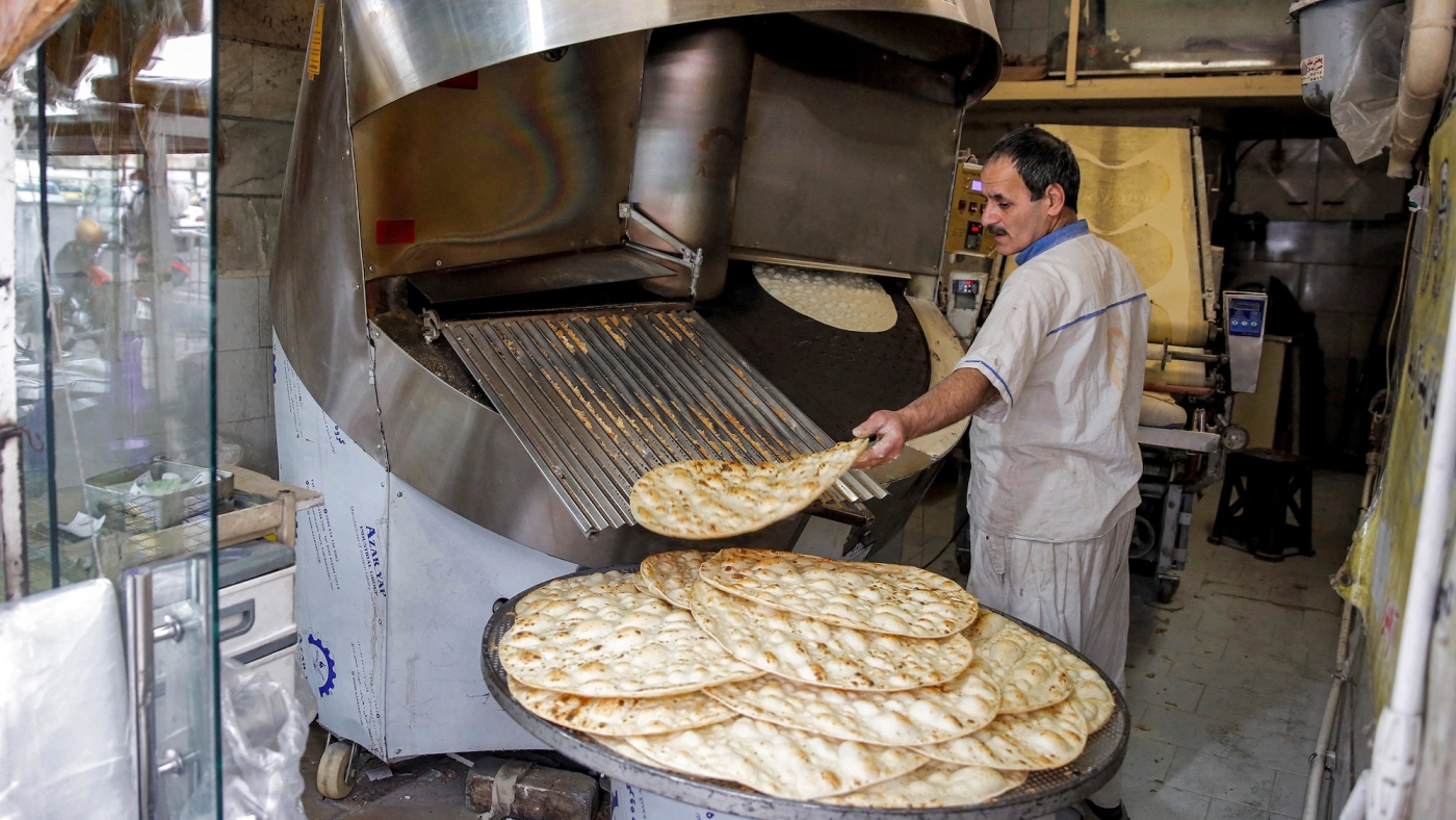 A baker extracts fresh taftoon bread at a bakery in southern of the capital city of Tehran, on 20 February, 2022 (AFP)