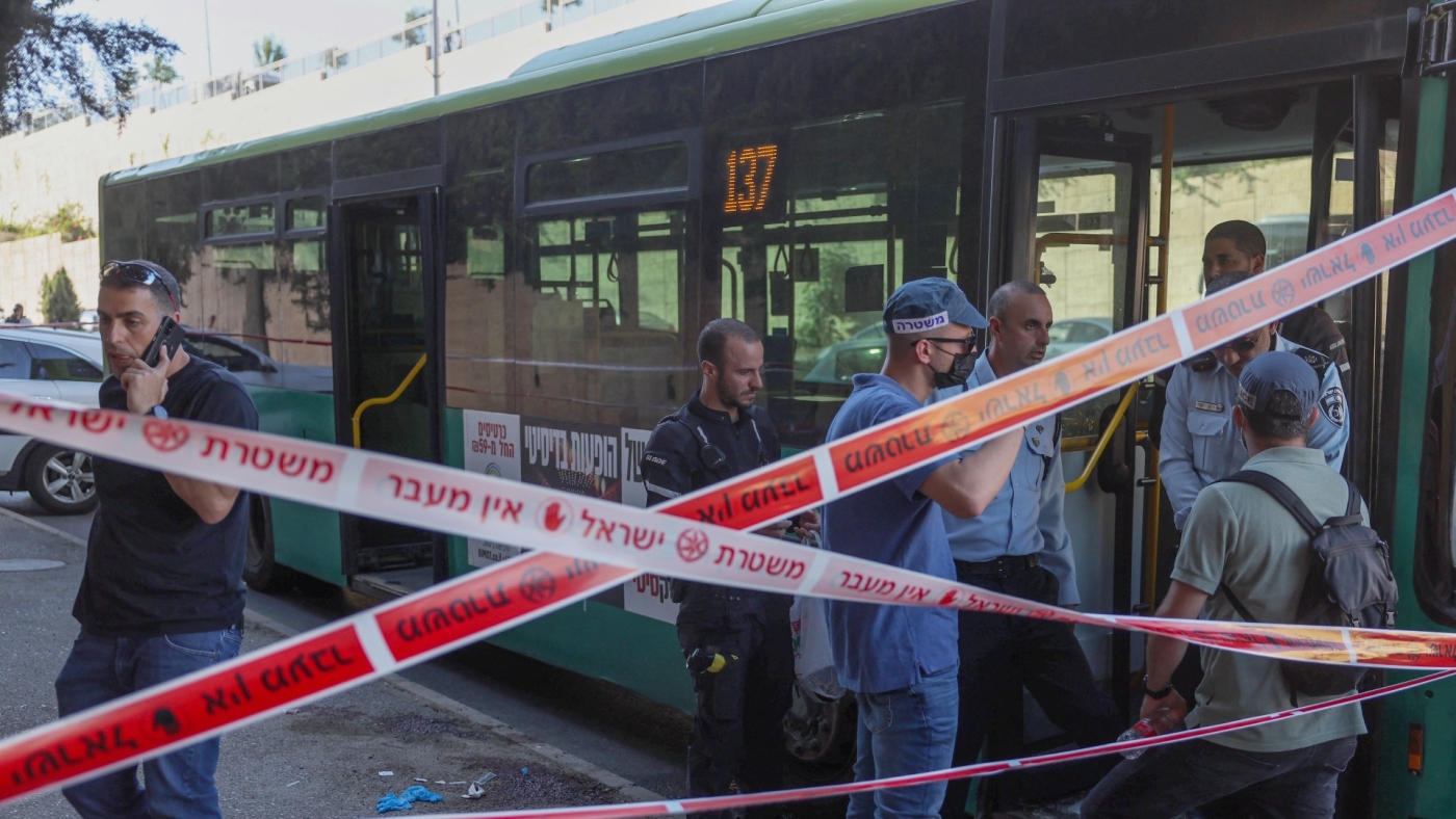 Israeli security and emergency service staff deploy at the site of a reported stabbing attack near Ramot, an illegal Israeli settlement in occupied east Jerusalem on 19 July 2022 (AFP)