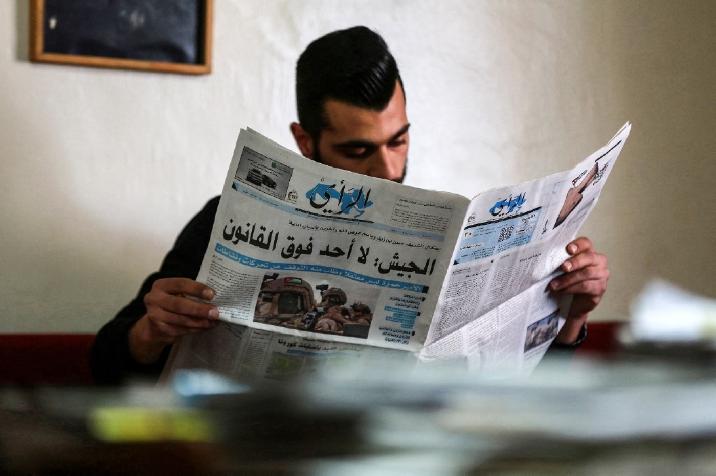 A Jordanian man reads a local newspaper in the capital Amman, on 4 April, 2021, with the headline: 'Army: No one is above the law' (AFP)