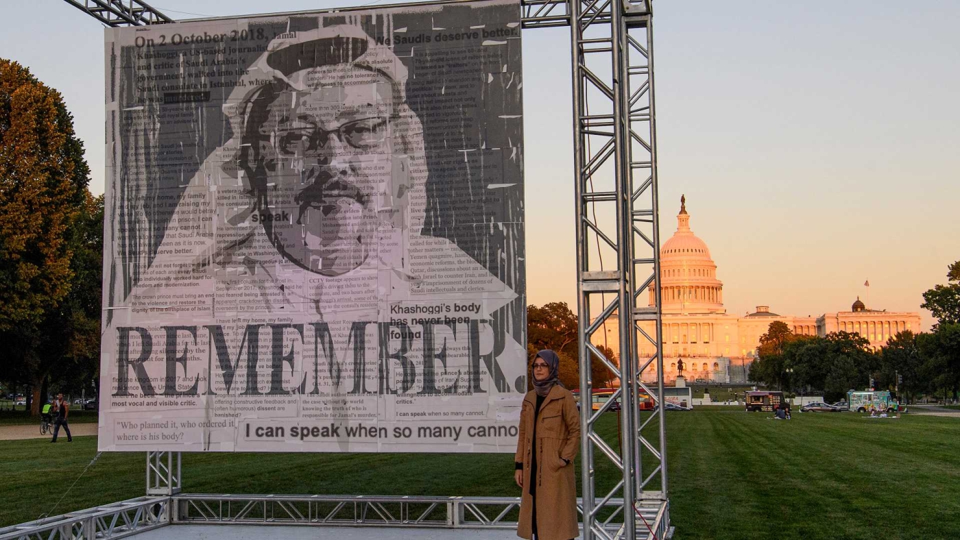 Hatice Cengiz, fiancée du journaliste saoudien assassiné Jamal Khashoggi, pose à côté de son portrait au National Mall à Washington DC, le 1er octobre 2021 (AFP)