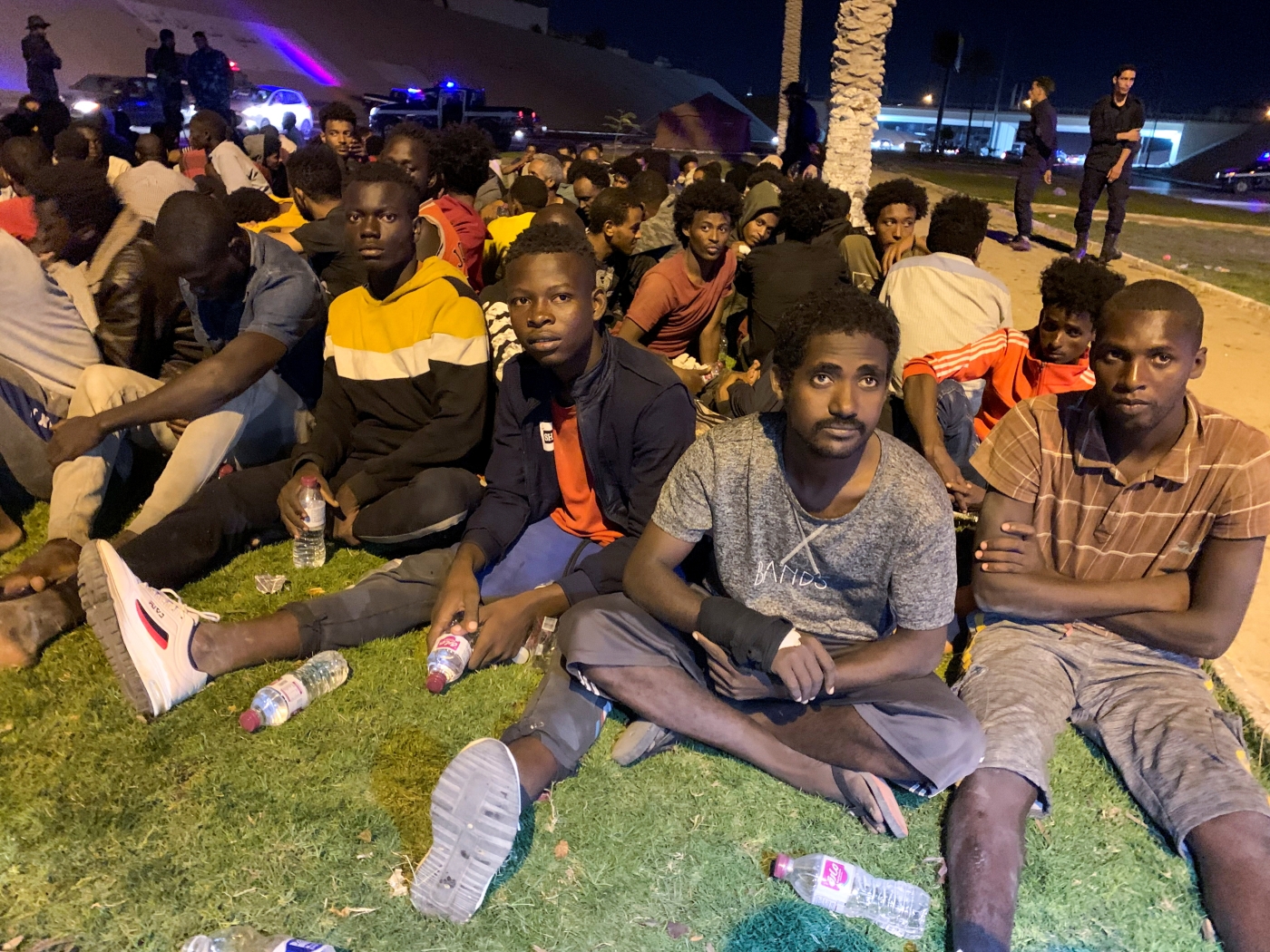 Migrants sit after they were detained by Libyan security forces in Tripoli, Libya on 8 October 2021