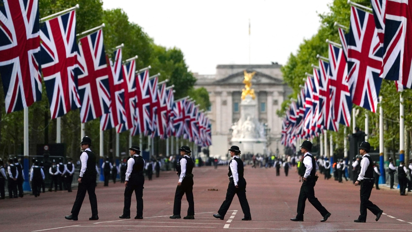 Des policiers en patrouille traversent The Mall avant la procession du cercueil de la reine Elizabeth II entre le palais de Buckingham et le palais de Westminster, le 14 septembre 2022 (AFP)
