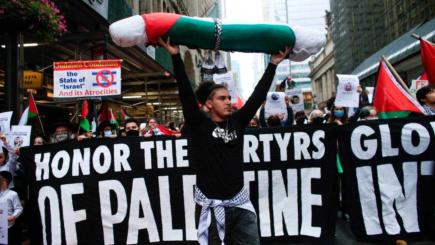 A man carries a fake body bag as people march to demonstrate in support of Palestinians in New York on 29 August 2021