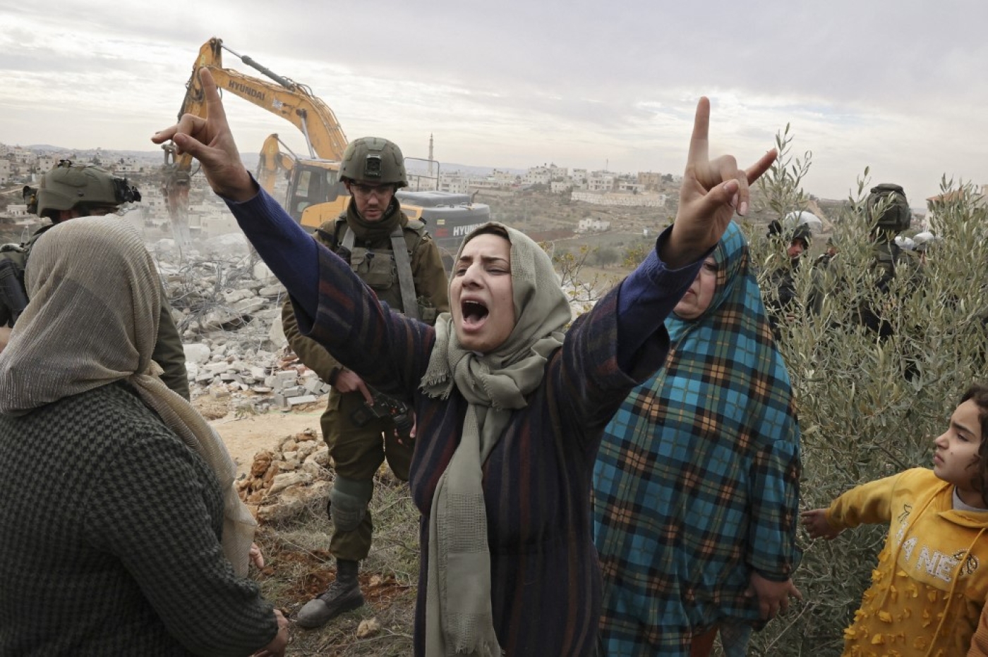 Des Palestiniennes s’insurgent contre la démolition, par l’armée israélienne, de leur maison dans la Zone C, en Cisjordanie occupée, à Hébron, le 28 décembre 2021 (AFP/Hazem Bader)