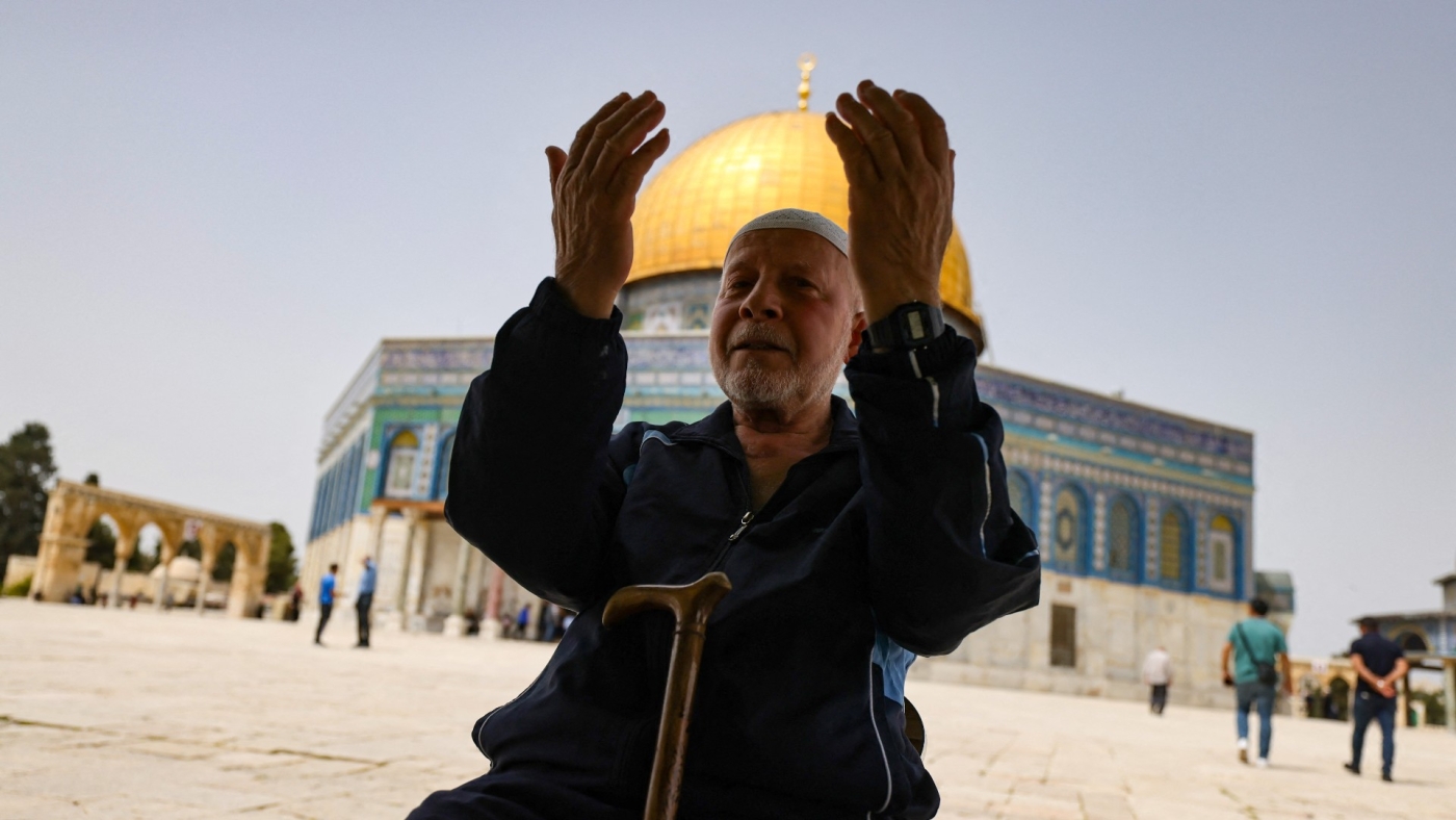 A Palestinian man prays in front of the Dome of Rock mosque at the Al-Aqsa mosque compound in Jerusalem's Old City on 17 April, 2022 (AFP)