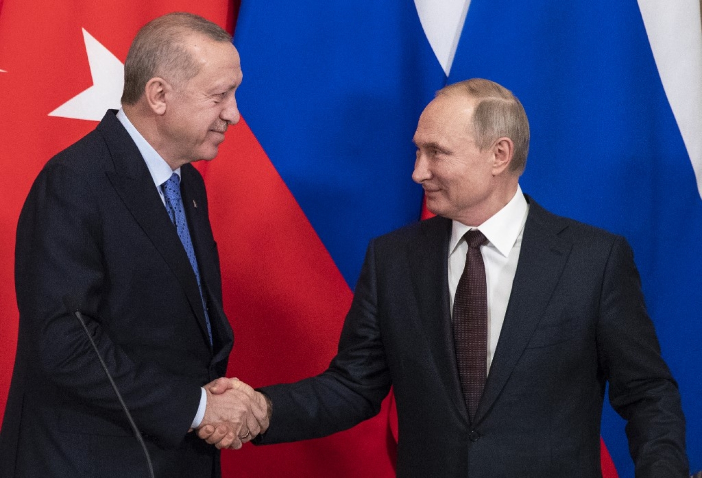 Turkish President Recep Tayyip Erdogan and Russian President Vladimir Putin shake hands in Moscow in March 2020 (AFP)