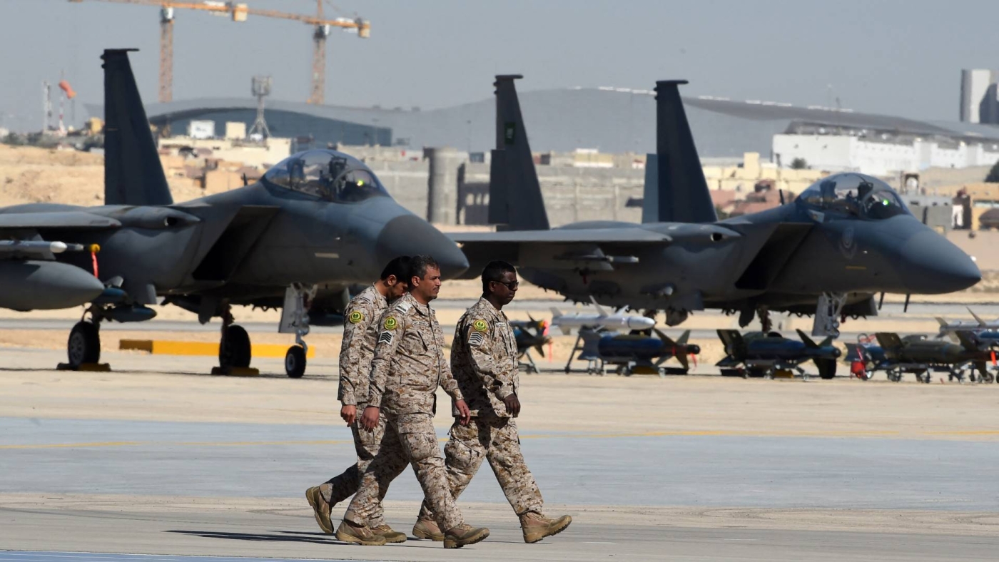 Saudi army officers walk past US-made F-15 fighter jets displayed at King Salman airbase in Riyadh on 25 January 2017.