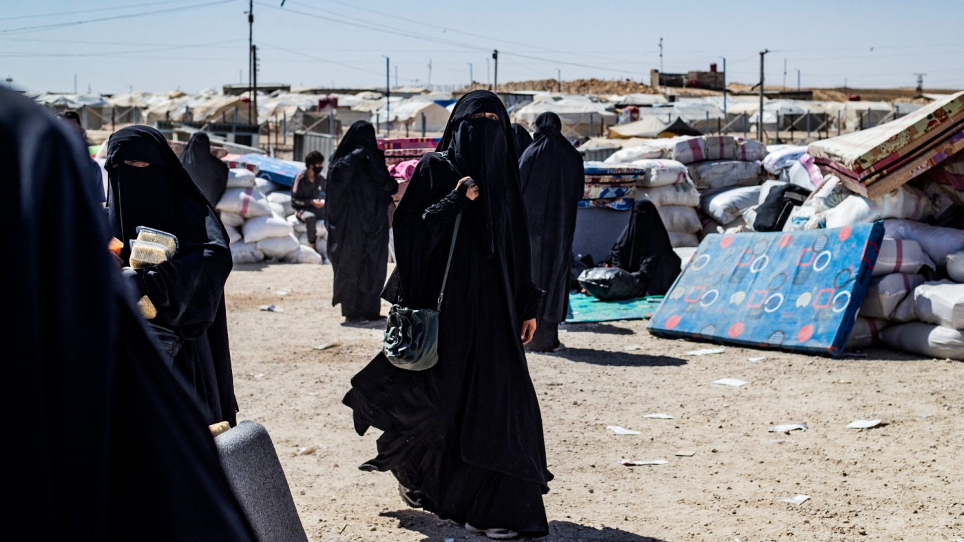 A fully veiled woman walks at the Kurdish-run al-Hol camp, which holds relatives of suspected Islamic State group fighters