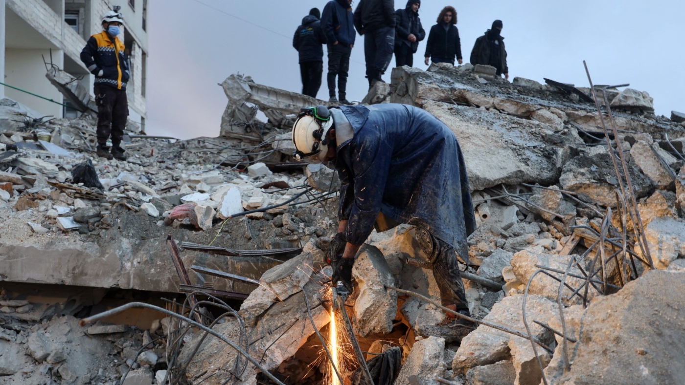 Members of the Syrian civil defence, known as the White Helmets, look for casualties following an earthquake in the town of Zardana, in northwest Syria's Idlib province on 6 February 2023 (AFP)