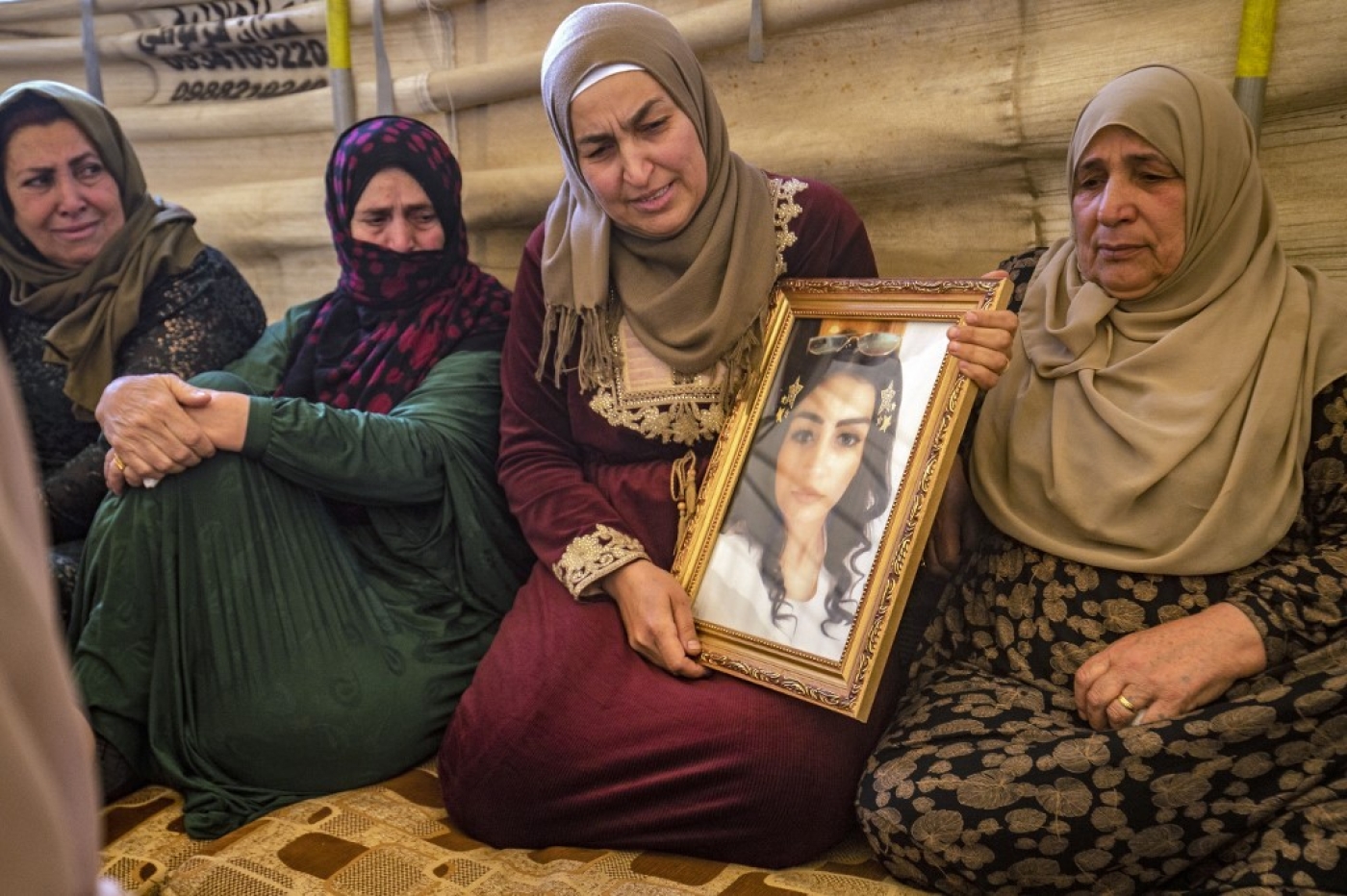 Hiam Saadoun montre la photo de sa fille, Inas, disparue en mer, lors de funérailles à Qamichli, dans le nord-est de la Syrie (AFP/Delil Souleiman)