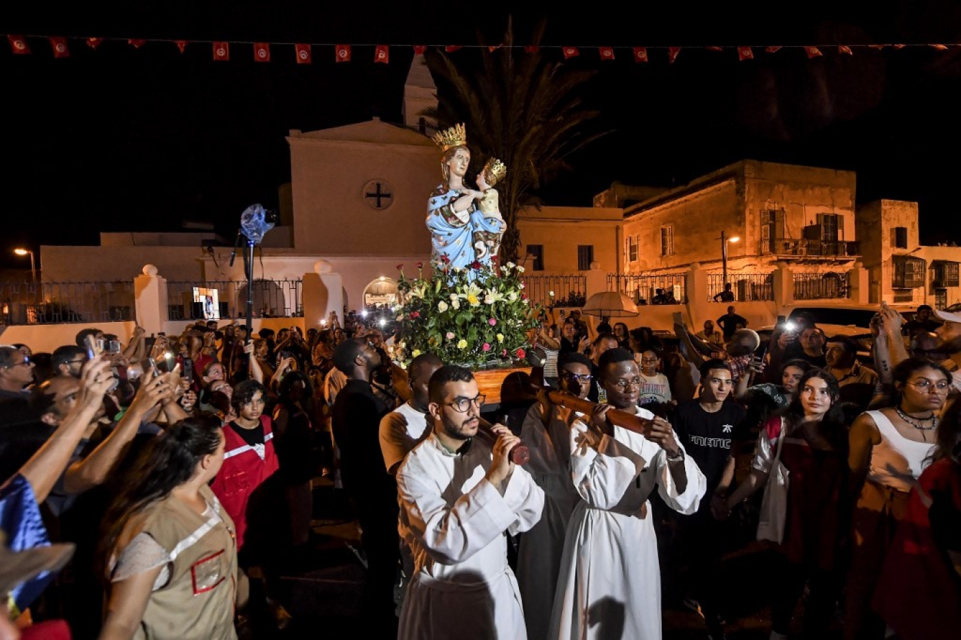 Procession de fidèles portant la « Madone de Trapani » à La Goulette, dans la banlieue de Tunis, le 15 août 2022  (AFP/Fethi Belaid)