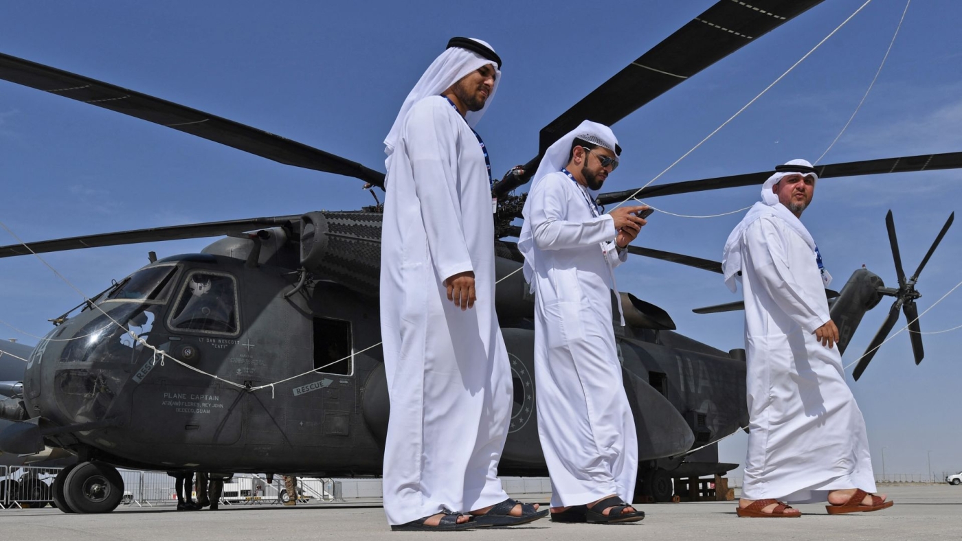 Emirati men walk past an American Sikorsky CH-53E Super Stallion at the Dubai Airshow on 18 November 2019.