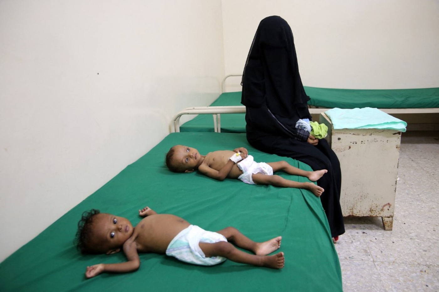 Une femme est assise à côté d’un enfant souffrant de malnutrition, dans un centre de traitement de la malnutrition, dans le village de Hays, dans la province occidentale de Hodeida, ravagée par la guerre au Yémen, le 11 juin 2022 (AFP/Khaled Ziad)