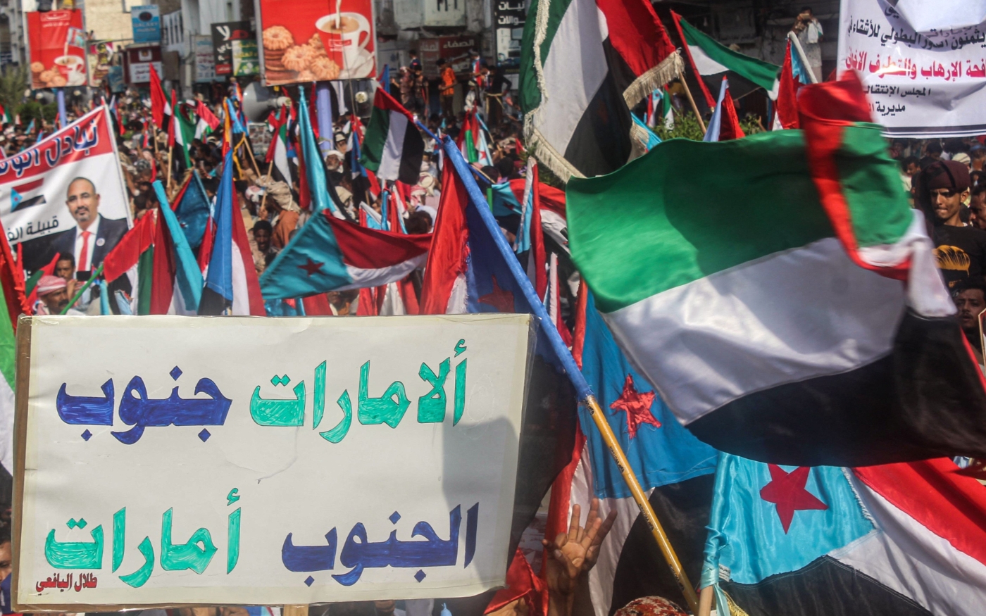 Des manifestants défilent avec un panneau proclamant en arabe « EAU Sud, Sud EAU » et des drapeaux du Yémen du Sud et des Émirats arabes unis à Aden, au Yémen, le 5 septembre 2019 (AFP)