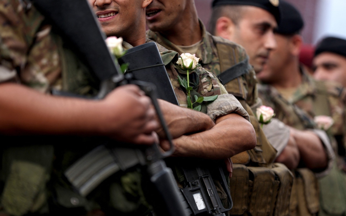 Des soldats libanais portent des roses offertes par des manifestants anti-gouvernementaux dans la région de Jal al-Dib, le 23 octobre 2019 (AFP)