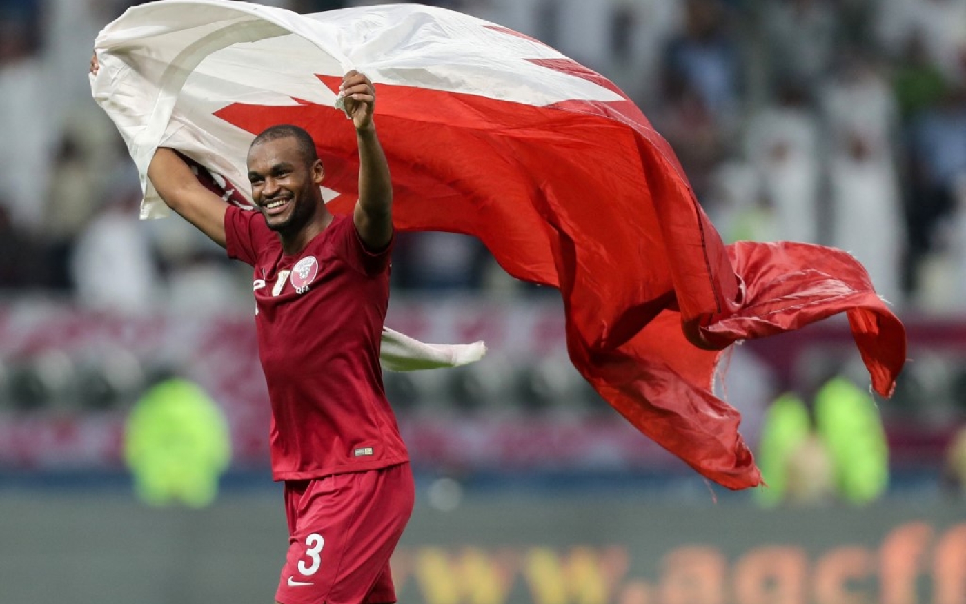 Le défenseur du Qatar Abdelkarim Hassan brandit le drapeau de son pays après la victoire de son équipe lors de la Coupe du golfe arabe entre le Qatar et les EAU, le 2 décembre 2019 (AFP/Karim Jaafar)