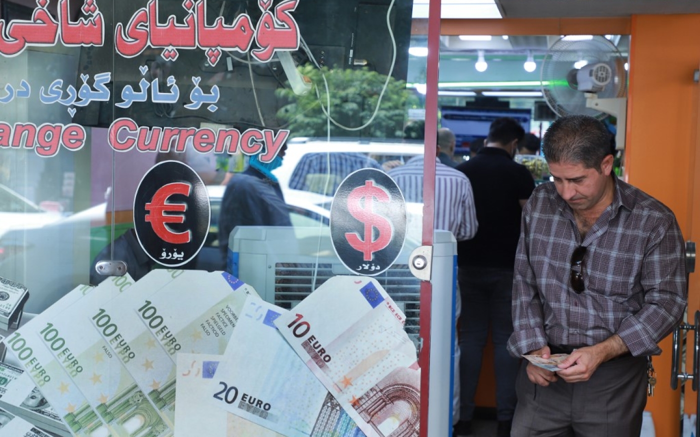 Un Irakien compte son argent alors qu’il quitte un bureau de change dans la ville de Souleimaniyeh, le 4 août 2020 (AFP)