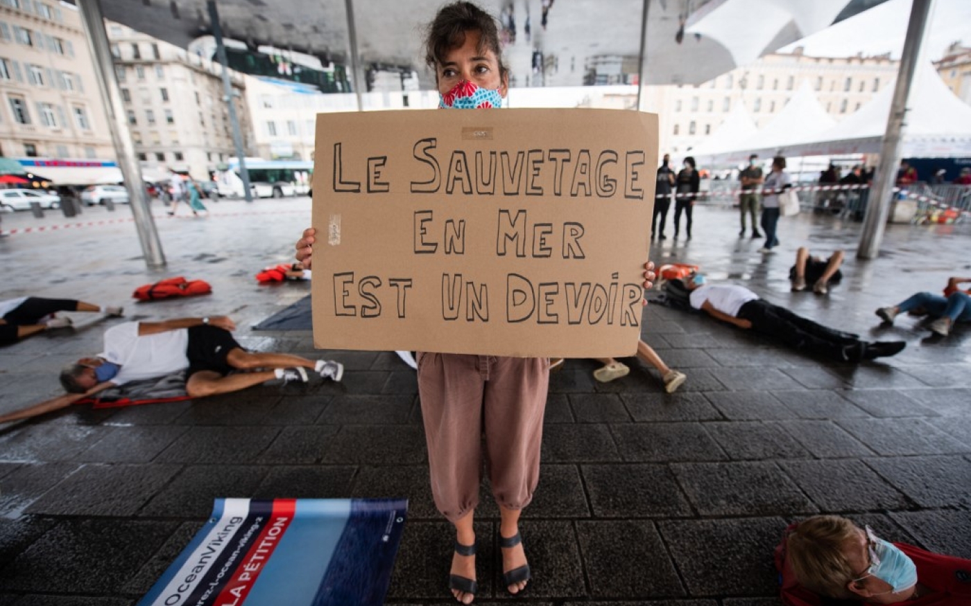 Une militante de l’ONG SOS Méditerranée tient une pancarte indiquant « Le sauvetage en mer est un devoir » sur le Vieux-Port de Marseille, le 29 août 2020, lors d’une manifestation pour exiger la libération par les autorités italiennes du navire Ocean Viking (AFP/Clément Mahoudeau)