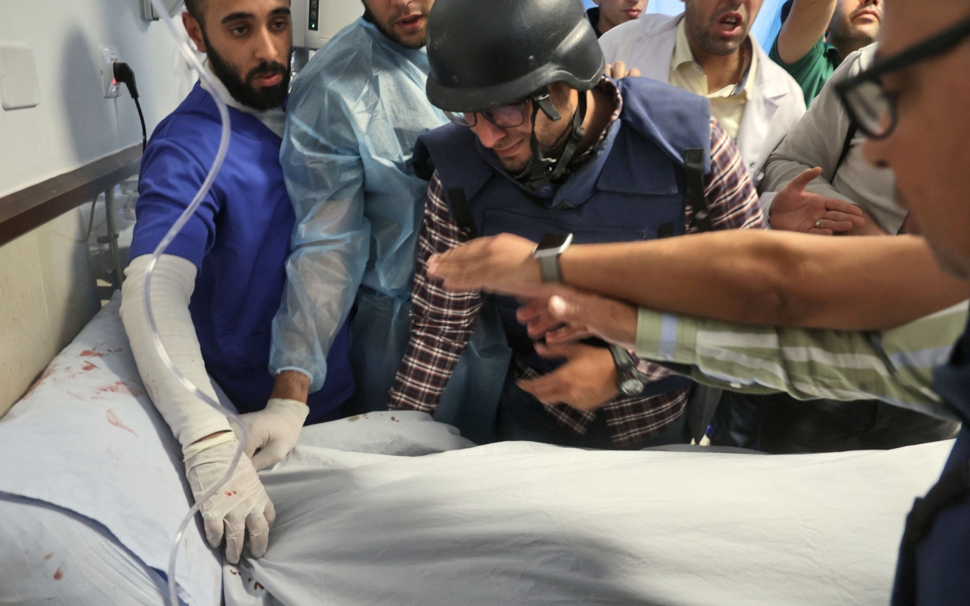 Le cameraman palestinien Mujahed al-Saadi, accompagné d’autres journalistes, pleure devant le corps de Shireen Abu Akleh (AFP)