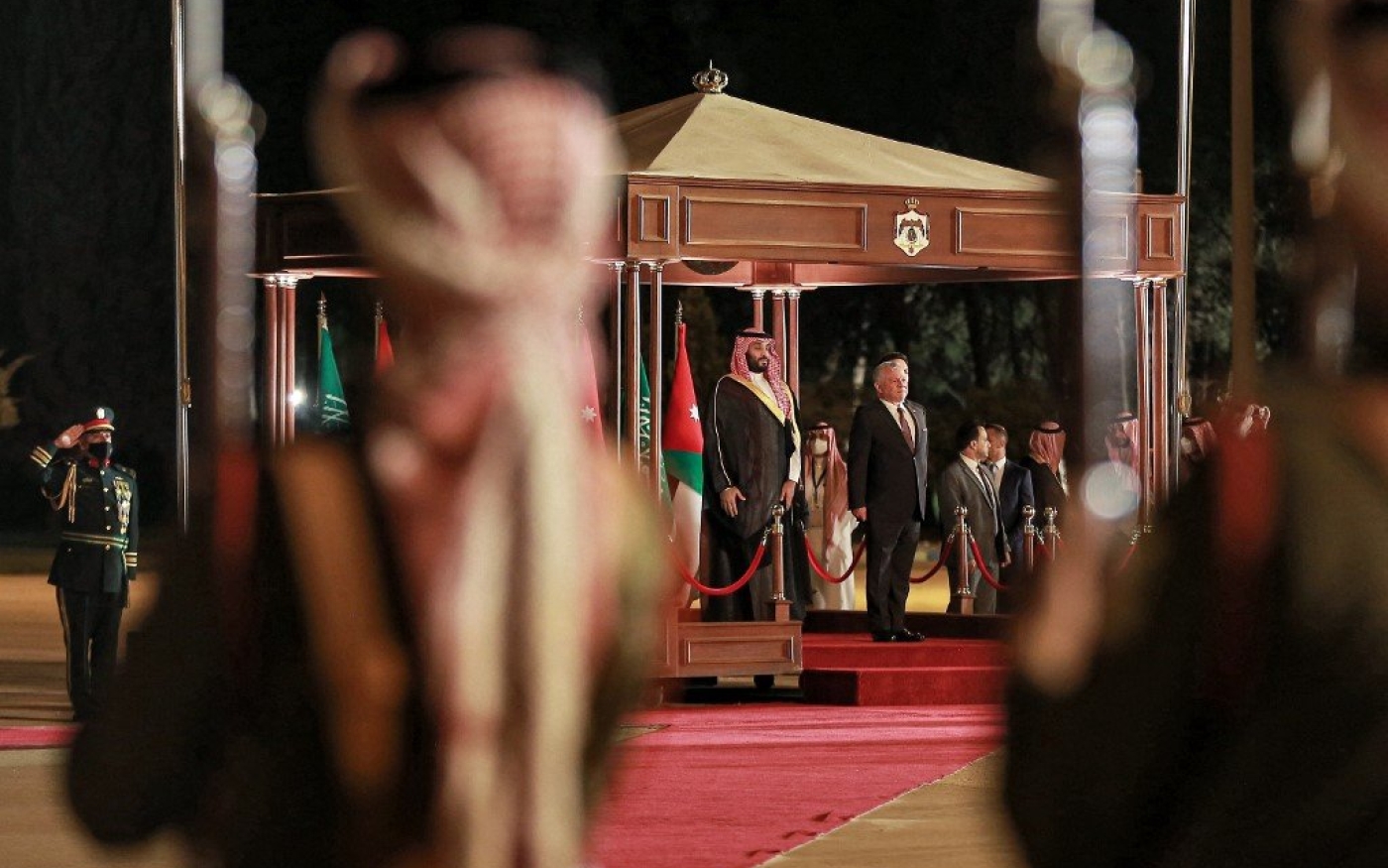 Le prince héritier saoudien Mohammed ben Salmane (à gauche) est reçu par le roi Abdallah II de Jordanie (à droite) et, derrière lui, son fils, le prince héritier Hussein, à son arrivée à Amman le 21 juin 2022 (AFP)