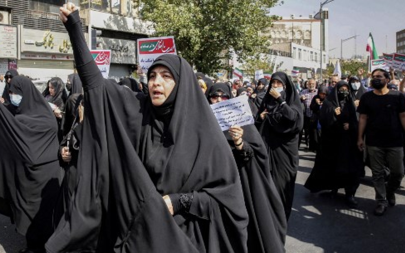 Des femmes et des hommes chantent des slogans lors d’un rassemblement pro-hijab dans la capitale iranienne Téhéran le 23 septembre 2022 (AFP)