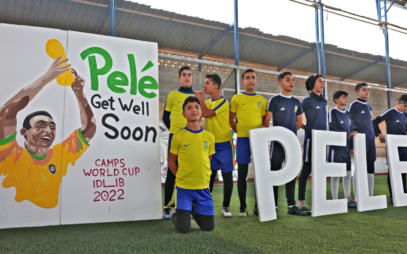 Des enfants syriens déplacés rendent hommage à Pelé avant un match au stade d’Hizano, dans le nord de la province d’Idleb, le 9 décembre (AFP)