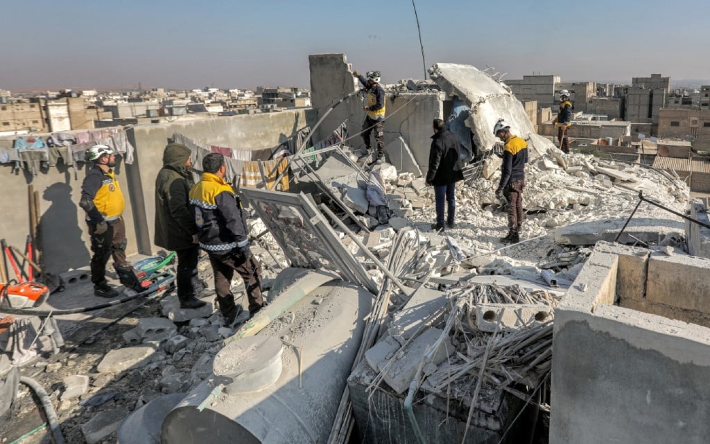 Des équipes de secours syriennes inspectent les dégâts sur le site d’une attaque de drone présumée de la coalition américaine dans la province d’Alep, le 20 décembre 2022 (AFP)