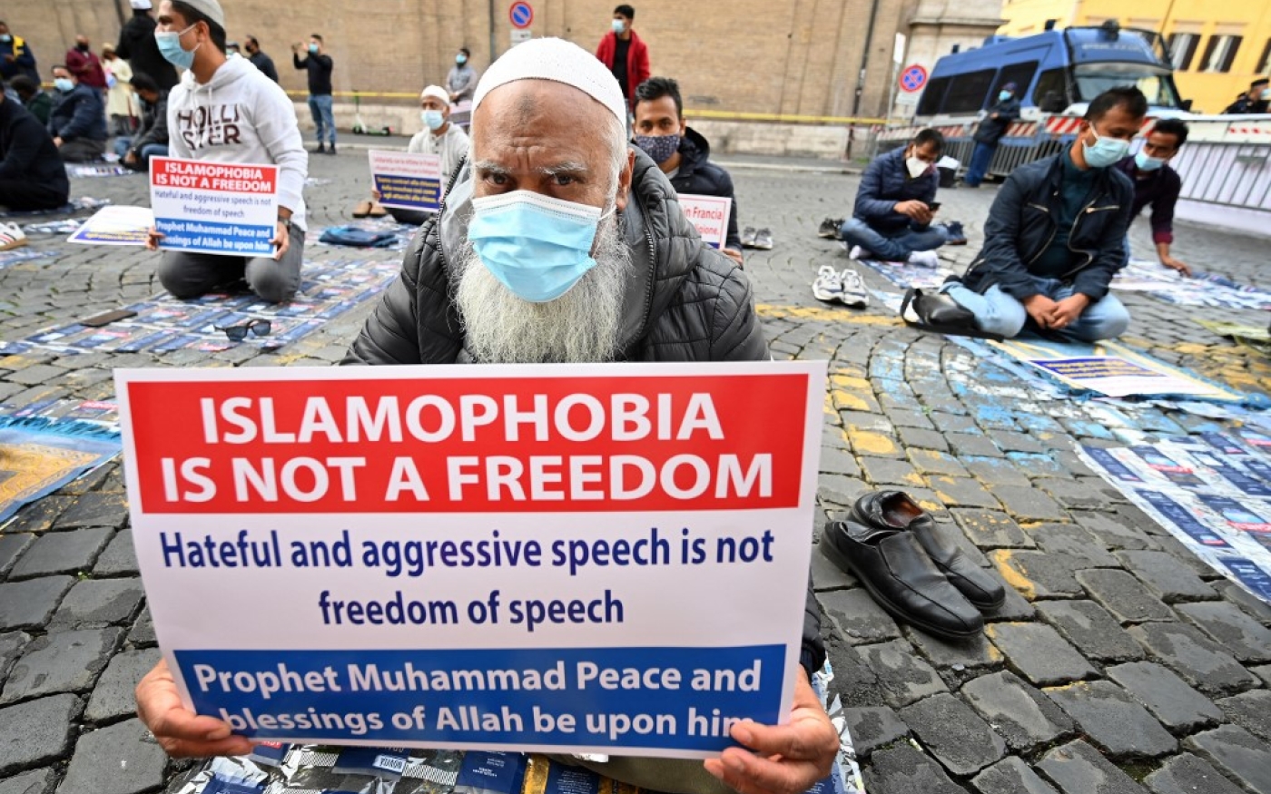 Des musulmans brandissent des affiches tandis qu’ils prient lors d’une manifestation contre l’islamophobie dans le centre de Rome, le 30 octobre 2020 (AFP)